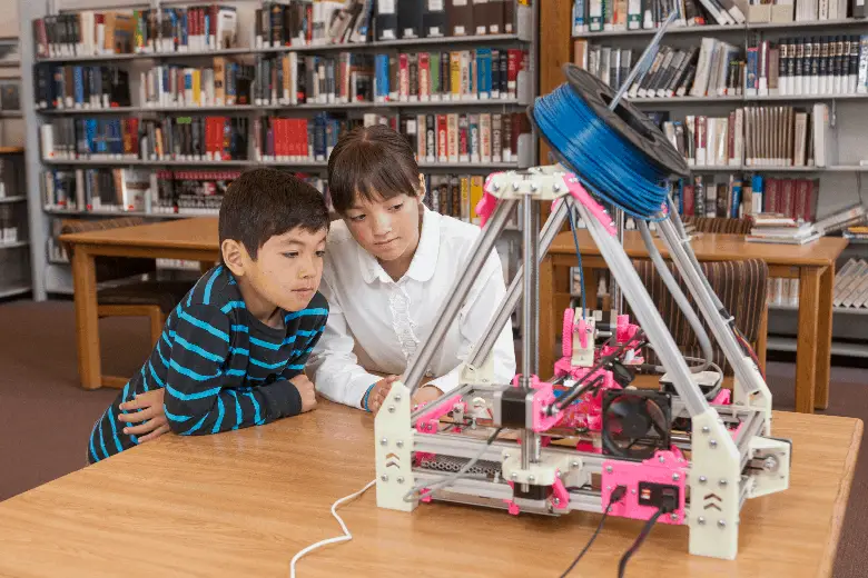 two kids using a 3d printer