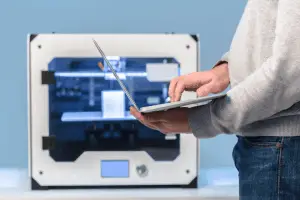 3d printer and man with laptop